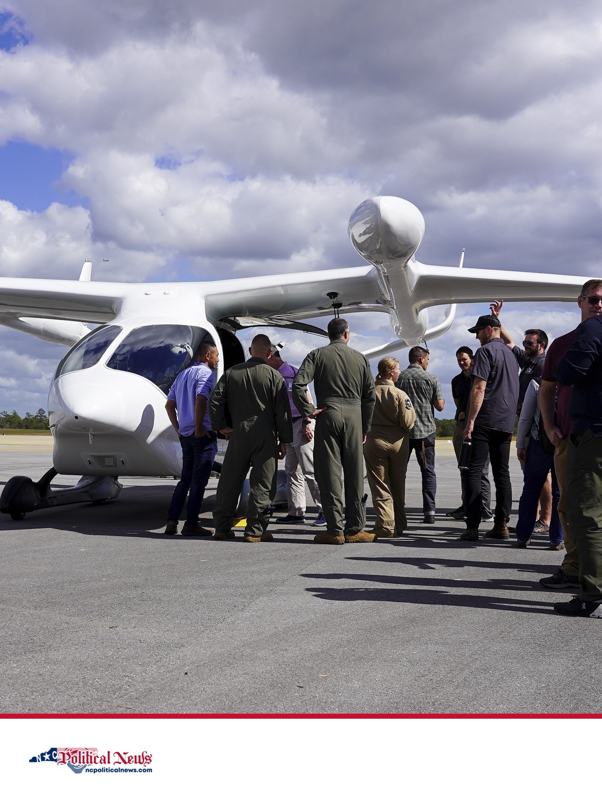 A BETA ALIA electric aircraft on a ramp as U.S. Air Force personnel and visitors gather beside it.