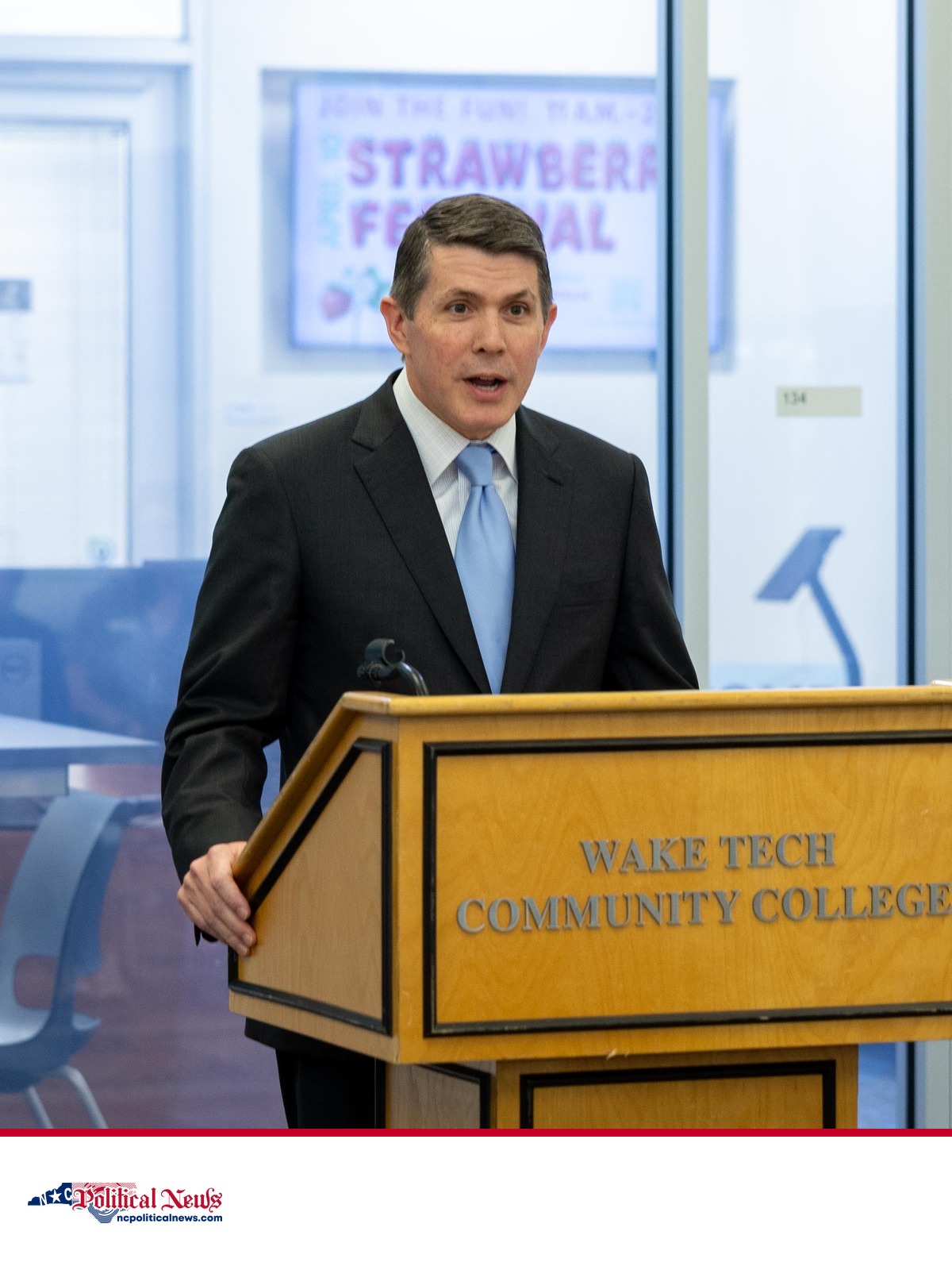 State Treasurer Brad Briner speaks at a podium above the NC Political News footer.