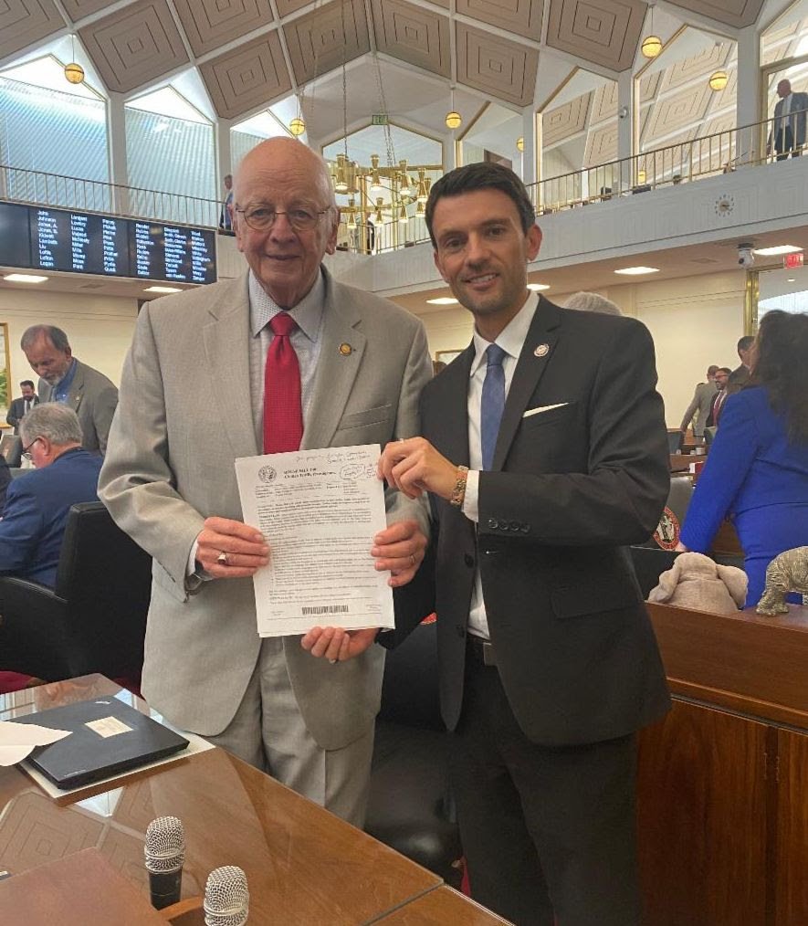  Rep. Jon Hardister with Rep. John Faircloth (R-Guilford) on the House floor holding a copy of the bill after it passed. Both are lead sponsors of the bill. 